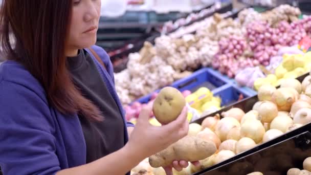 食料品店でニンニクを選ぶアジアの女性 — ストック動画