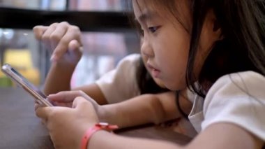 Asyalı çocukların küçük kızları evde akıllı telefon kullanıyorlar, günlük yaşam tarzı videoları..