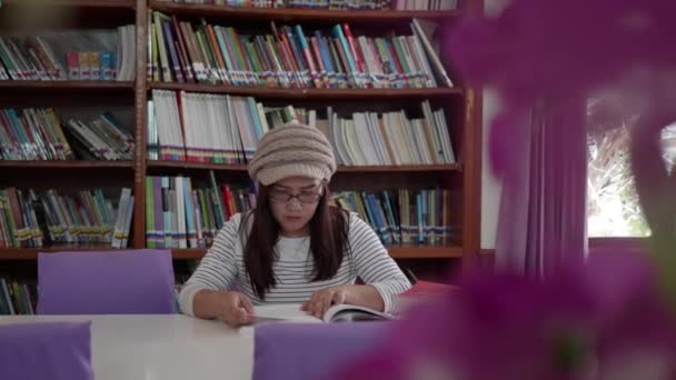 Asian Woman Sitting Front Bookshelves Reading Book University Library — Stock Video