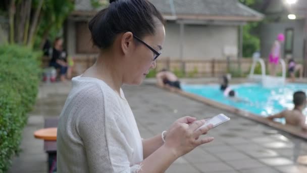Mujer Asiática Jugando Smartphone Teléfono Móvil Cerca Piscina Relajante Cerca — Vídeos de Stock