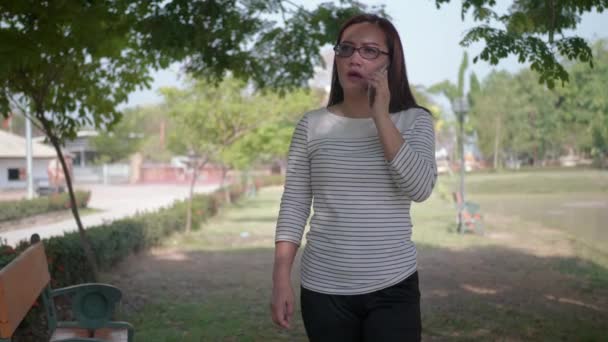 Glücklich Asiatisch Frau Brille Sprechen Auf Das Handy Beim Gehen — Stockvideo