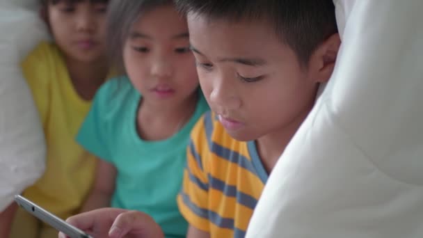 Aziatische Kinderen Gebruiken Tablet Onder Deken Het Bed — Stockvideo