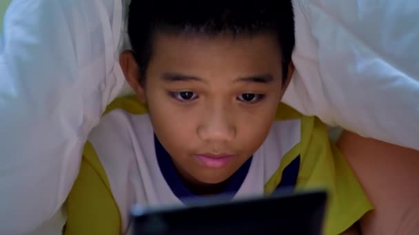 Asiatico Bambini Ragazzo Utilizzando Tablet Sotto Coperta Letto — Video Stock