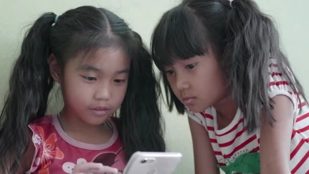 アジアの子供たちの女の子は自宅でスマートフォンを使用して — ストック動画