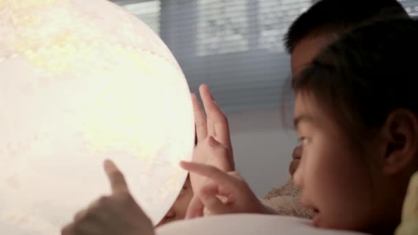 アジアの子供たちが寝室で地理について学ぶ — ストック動画
