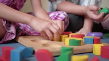 Mutlu Asyalı Aile, Genç Anne ve kızları evde birlikte ahşap oyuncak blok oynuyor.