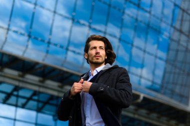 Yakışıklı bir işadamının portresi telefon ve kahve fincanı şehir sokaklarında.