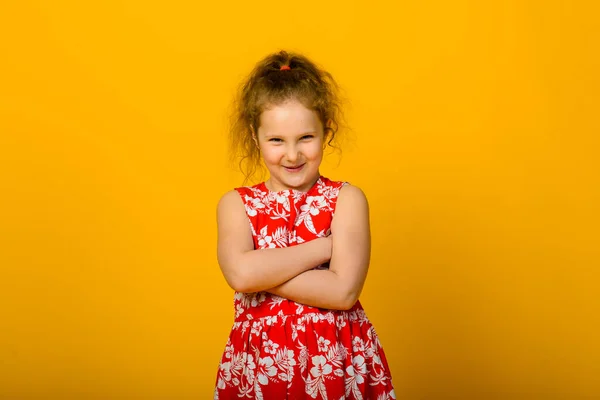Happy carefree child emotions. Energetic joyful adorable little girl laughing at joke on yellow background in studio.
