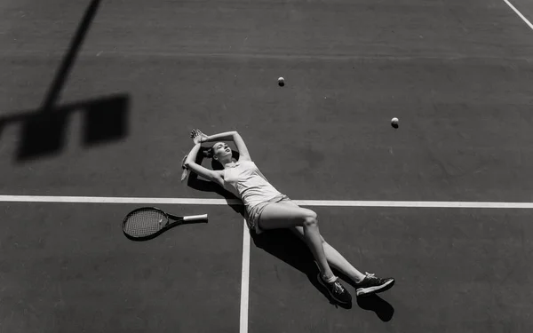 穿着白衣和高跟鞋的性感女子网球选手在球场上拿着网球拍 年轻女人在打网球 — 图库照片
