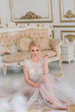 Kavramsal düğün, gelinin Avrupa tarzında bir sabah. İç stüdyoda özel bir elbise var. Gelin için beyaz minimalizm