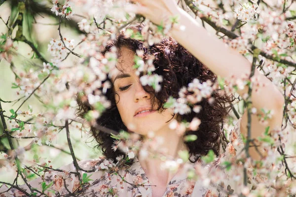 Mujer Atractiva Joven Con Pelo Largo Rizado Posando Jardín Floreciente —  Fotos de Stock