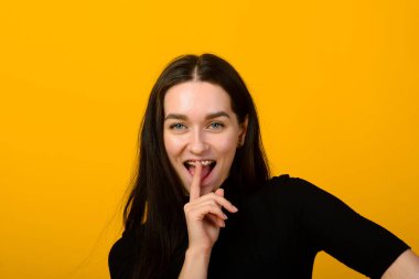 Wow. Beautiful female half-length front portrait isolated on yellow studio backgroud. Young emotional surprised woman standing with open mouth. Human emotions, facial expression concept. clipart