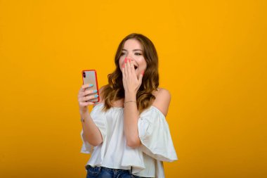 Dijital cihazlı heyecanlı kadın. Stüdyo fotoğrafı, elinde akıllı telefon tutan şok olmuş bir kız..