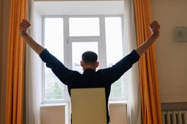 Rahatlamış genç adam işten dinleniyor. Adam ofis işyerinde mola vermeyi seviyor.