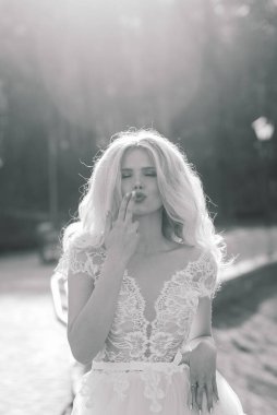 Minsk, Belarus - 05.05.2020. Parkta yürüyen ve gülümseyen kıvırcık saçlı sarışın gelin, konsept düğün.