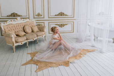 Kavramsal düğün, gelinin Avrupa tarzında bir sabah. Yatak odası elbisesi, iç stüdyodaki ücretler. Gelin için beyaz minimalizm