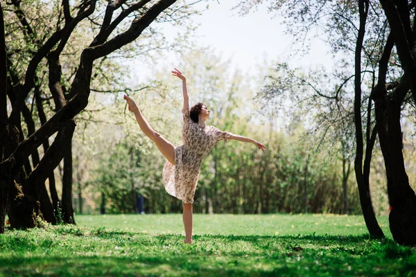 Woman ballerina in blooming garden. pink. Portrait of dancing female outdoor.