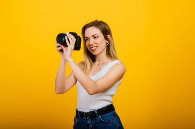 Stüdyoda çalışan heyecanlı bayan fotoğrafçı. Çekici sarışın kızın fotoğrafı. Kameralı..