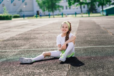 Güneşli bir yaz akşamında koşan kız, koşu bandında, stadyumda uzanan, fiziksel antrenman yapan, okula dönen, yorgun.