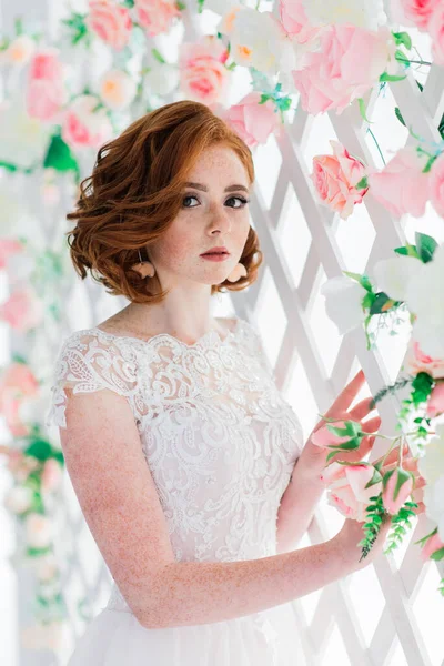 白いと灰色のスタジオの背景に結婚式のドレスを着て赤い髪の女の子の肖像画 — ストック写真