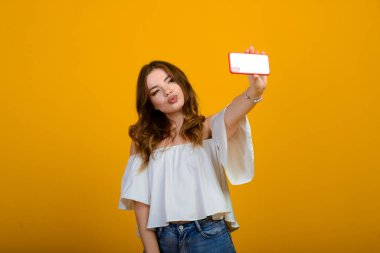 Dijital cihazlı heyecanlı kadın. Stüdyo fotoğrafı, elinde akıllı telefon tutan şok olmuş bir kız..