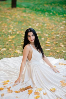 Güz parkında uzun beyaz elbiseli güzel esmer kadın..