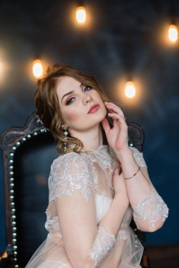 Beyaz iç çamaşırlı güzel bir gelin. Düğün için son hazırlıklar. Kız damadı bekliyor..