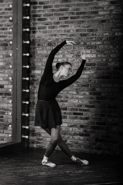 暗いボディスーツのバレリーナ 暗いインテリアスタジオでドレス レンガの壁 ピアノ 木造床 — ストック写真