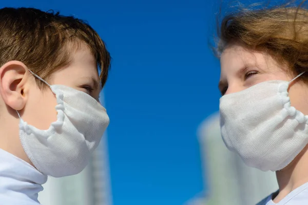 Children in a city park in a medical mask. Walking on the street during the quarantine period of the coronavirus pandemic in the world. Precautions children