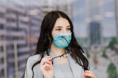 Halka açık bir yerde koruyucu maskeli bir kadın. Coronavirus, COVID-19 yayılma önleme kavramı, vatandaşların sorumlu sosyal davranışları