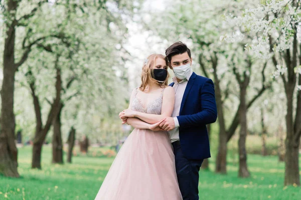 Düğün günlerinde karantina sırasında parkta maske takan genç bir çift. Coronavirus, hastalık, koruma, hastalık. Avrupa kutlamaları iptal edildi.