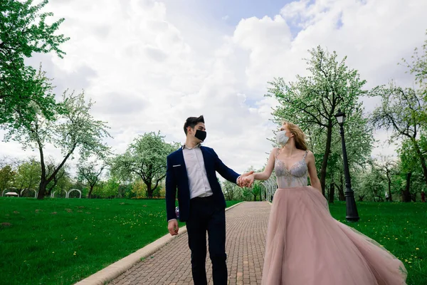 Fiatal Szerelmesek Orvosi Maszkban Sétálnak Parkban Karantén Alatt Esküvőjük Napján — Stock Fotó