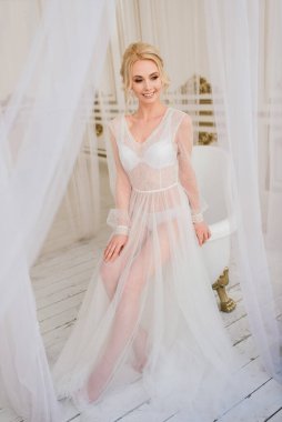 Kavramsal düğün, gelinin Avrupa tarzında bir sabah. Yatak odası elbisesi, iç stüdyodaki ücretler. Gelin için beyaz minimalizmi