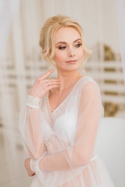 Kavramsal düğün, gelinin Avrupa tarzında bir sabah. Yatak odası elbisesi, iç stüdyodaki ücretler. Gelin için beyaz minimalizmi