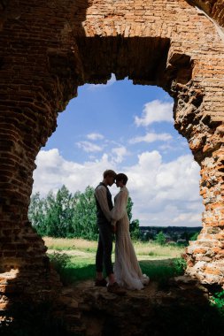 Çok hoş kızıl saçlı genç evli mutlu bir çift gün batımında dışarıda öpüşüyor.