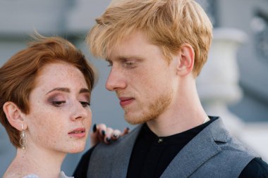 Çok hoş kızıl saçlı genç evli mutlu bir çift gün batımında dışarıda öpüşüyor.