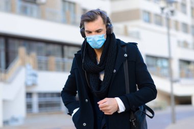 Yüz maskeli insanlar. Kopyalama alanı kavramı. Grip karantinasında yetişkin bir adamın portresi. Şehirde sokak fotoğrafı var.