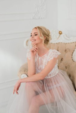 Kavramsal düğün, gelinin Avrupa tarzında bir sabah. Yatak odası elbisesi, iç stüdyodaki ücretler. Gelin için beyaz minimalizmi