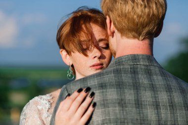 Kapalı oyun parkında yüzü maskeli, üzgün, beyaz bir çocuğun portresi. Coronavirus sosyal mesafesi.