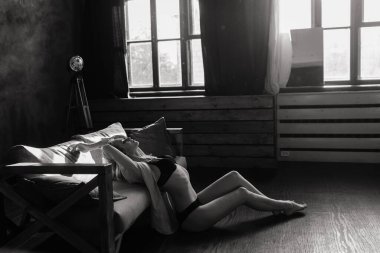 Siyah iç çamaşırlarıyla poz veren seksi sarışın ve stüdyoda beyaz gömlekli.