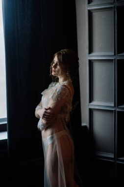 Beyaz iç çamaşırlı güzel bir gelin. Düğün için son hazırlıklar. Kız damadı bekliyor..