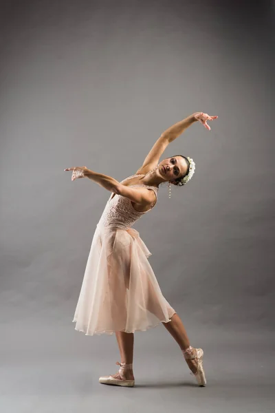 Молодая Красивая Балерина Бежевом Купальнике Позирует Пуантах Светло Сером Фоне — стоковое фото