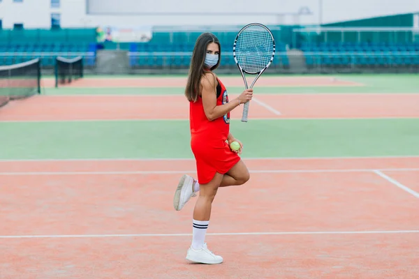 보호용 마스크를 착용하고 라켓을 테니스 선수의 테니스를 소녀와 라켓을 밖에서 — 스톡 사진