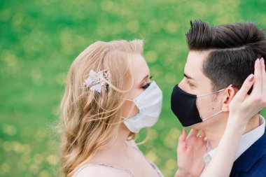 Düğün günlerinde karantina sırasında parkta maske takan genç bir çift. Coronavirus, hastalık, koruma, hastalık. Avrupa kutlamaları iptal edildi.