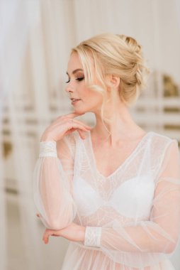 Kavramsal düğün, gelinin Avrupa tarzında bir sabah. Yatak odası elbisesi, iç stüdyodaki ücretler. Gelin için beyaz minimalizmi