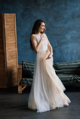 Gelinin sabahı. Beyaz dantel iç çamaşırıyla poz veren seksi kız. Beyaz iç çamaşırlı güzel bir kadının portresi. Beyaz çarşaflı baştan çıkarıcı kadın ve bir peignoir..