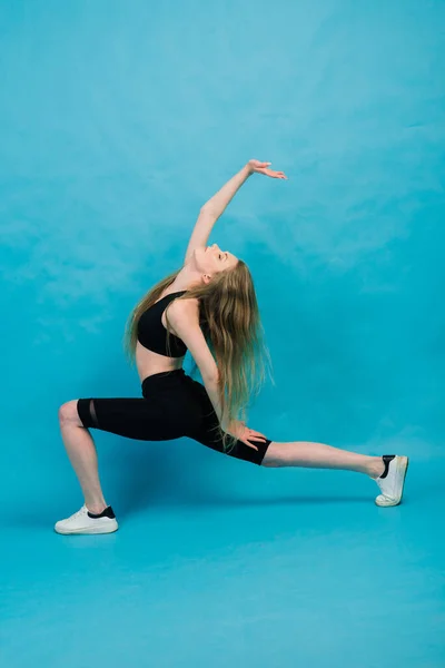 Forma Donna Abbigliamento Sportivo Gambe Stretching Riscaldamento Sfondo Blu — Foto Stock