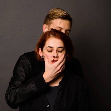 Stüdyoda saldırgan bir adamla umutsuz bir kadın, aile içi şiddet kavramı