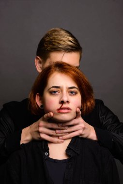 Stüdyoda saldırgan bir adamla umutsuz bir kadın, aile içi şiddet kavramı