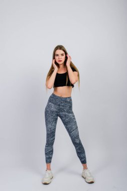 Gülümseyen genç fitness kadınının tam boy portresi. Mükemmel durumda, stüdyo çekimi.